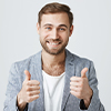image of a man in a suit with t-shirt, smiling with two thumbs up 